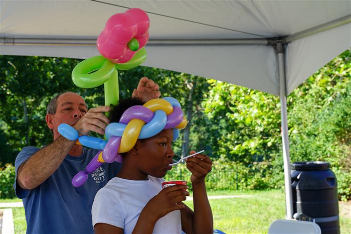A child wears a balloon hat during the AIU Back-to-School Celebration